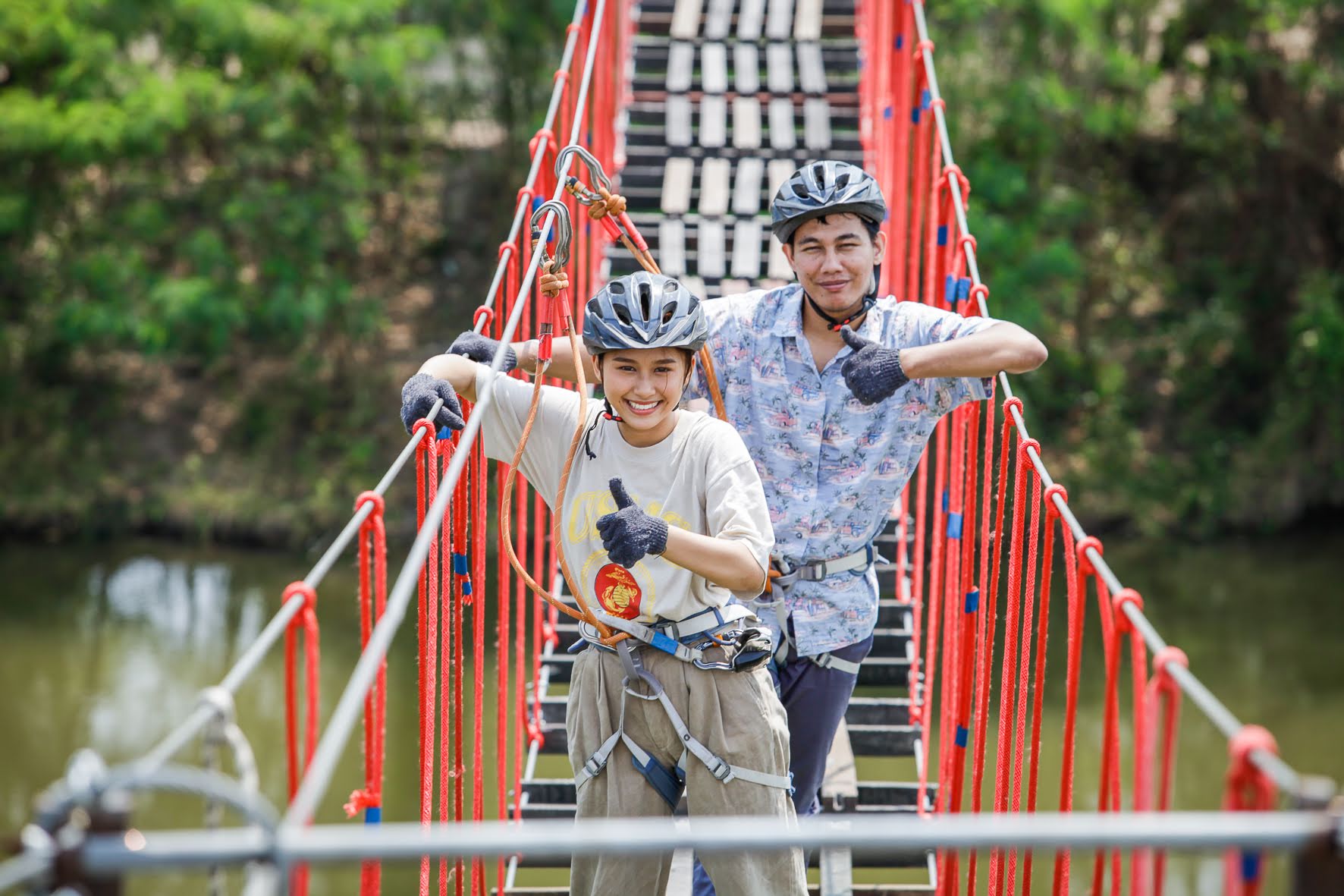 Guests crossing a red rope bridge with their guide