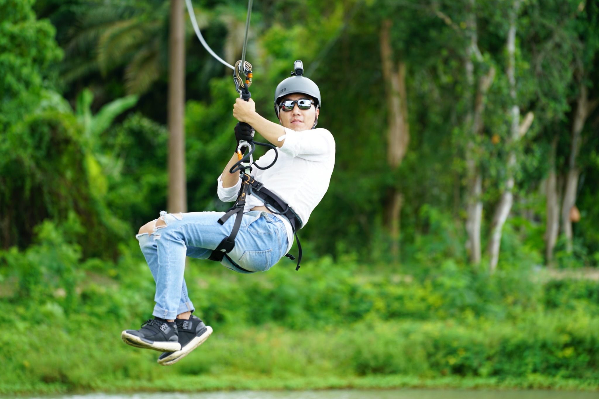 Guest enjoying a zipline above a green landscape